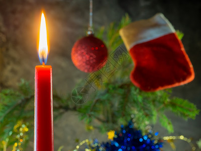 圣诞红背景圣诞红蜡烛在Fir树枝的背景下烧伤背景