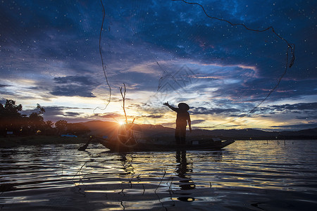 利用泰国的阳光 自然与文化概念在船上使用网钓渔高清图片