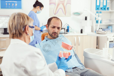 患有牙科牙刀的高级妇科病理学高龄妇女老年男人射线配饰考试工具假牙助手医师骨骼背景图片