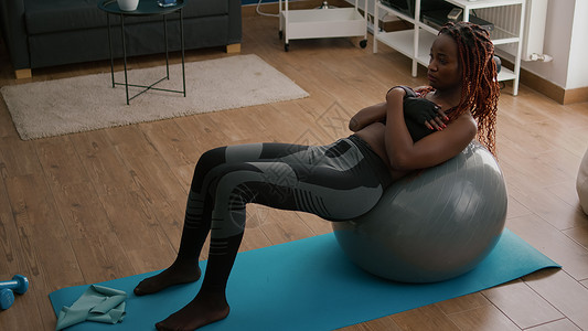 瑜伽瑞士球早上在客厅做健身锻炼的体育黑人妇女身体肌肉福利有氧运动保健闲暇训练运动装运动员瑜伽背景