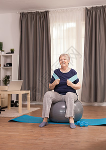 瑜伽瑞士球使用抗药性带的健康老年妇女背景