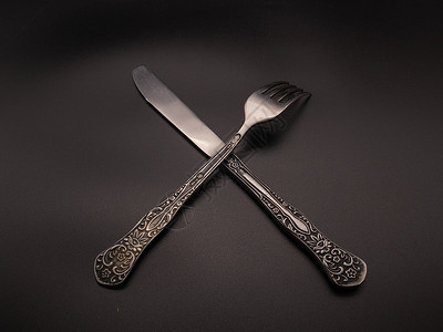 金叉黑暗背景上的勺子和叉子背景