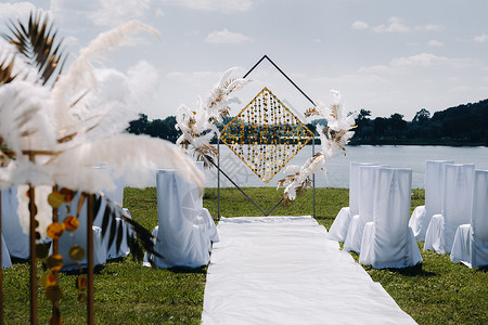 我们订婚了举行婚礼仪式 在湖面背景上装饰了古老羽毛的拱门 掌声订婚风格奢华框架假期婚姻接待椅子亮片庆典背景