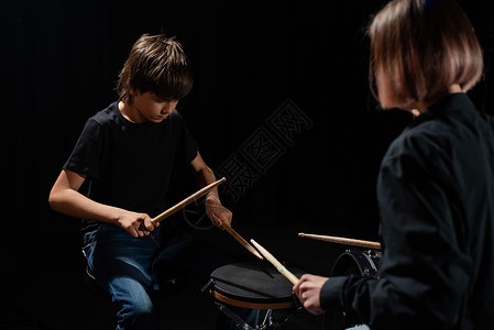 黑色.男孩年轻的天主教女青年教男孩用黑人背景在工作室里打鼓 音乐学校学生 请讲作曲家艺术家黑色笔记鸡腿娱乐教学爱好天赋孩子背景