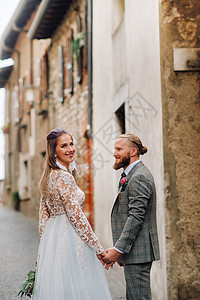 美丽的家庭 在意大利西尔米奥内老城散步 一对夫妇在意大利老城漫步景点夫妻外套摄影游客城市好心情好天气旅游女士背景