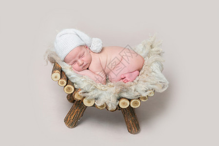 新生儿睡在木制婴儿床上高清图片