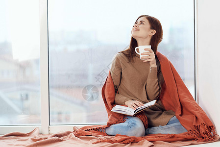 女人在窗台上喝着一杯酒 在清晨读一本书杯子咖啡格子假期女性思维闲暇女孩女士背景图片