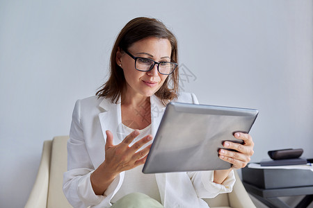 心理网站素材观看数字平板电脑屏幕的有声谈女商业妇女技术眼镜社交人士女士商务自由职业者伙伴经理中年背景