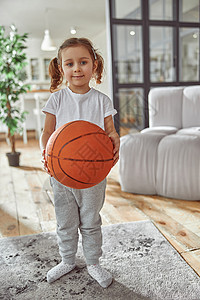 快乐的女孩在客厅打篮球背景图片