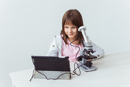 在科学课中使用显微镜的女学生 技术 课程和儿童概念化学科学家光学测试学校学生白色教育腰围检查背景图片