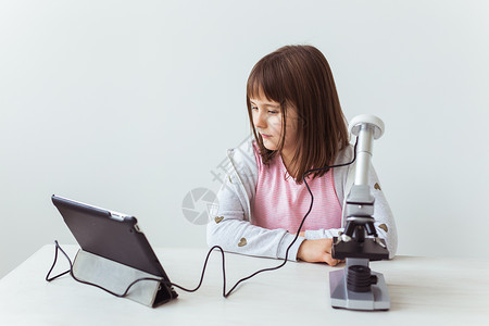 在科学课上使用数码显微镜的女童 技术 儿童和学习理念团体专注化学教程检查实验微笑班级桌子课堂背景图片