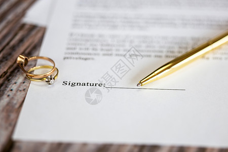 作品登记证书与两个金婚戒指和金笔的婚姻合同 婚前协议 宏观特写 签名 文件 协议概念法令证书订婚珠宝家庭商业仪式婚礼法律离婚背景