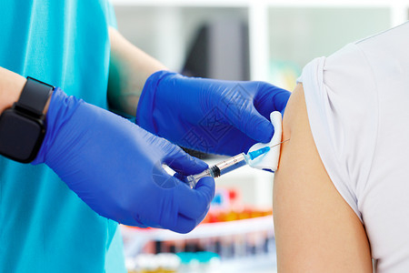 新冠疫苗加强针医生亲手在病人的肩上接种疫苗肩膀注射器注射从业者免疫治疗背景