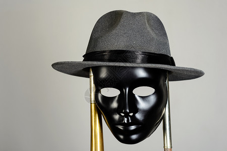 黑戏面具和帽子挂在铜管上高清图片