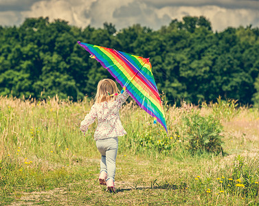彩虹跑可爱的小女孩在放风筝女学生彩虹公园女性跑步乐趣草地喜悦活动场地背景