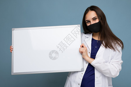 身穿白色医疗大衣和面罩的女医生 戴着空白板 有在背景上隔绝文字的复制空间Corona病毒概念医师防护小样外套面具护士女士药品磁板背景图片