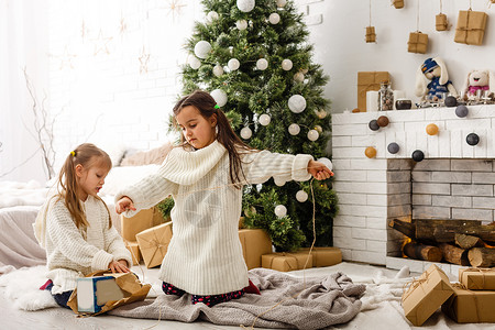 喋不休的礼物圣诞节背景中的两个小女孩黑发展示女孩微笑雪花青少年幸福礼物耳朵魔法背景