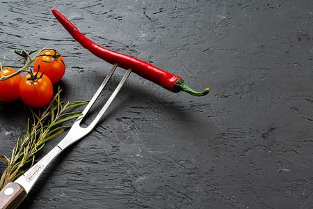 红色厨房黑石背景的叉子上的红辣椒辣椒厨房蔬菜胡椒烹饪石头银叉节食燃烧植物食物背景