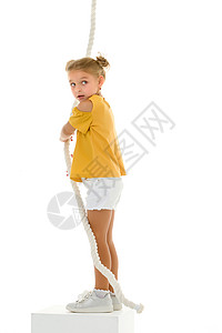 小女孩跳绳一个小女孩用手抓住绳子 挥舞着绳子跳跃孩子喜悦闲暇玩具跳绳幸福绳索乐趣活动背景