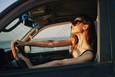 开小汽车的女孩以时装旅行方式驾驶汽车的妇女商业太阳交通女孩眼镜阳光女性太阳镜车轮乘客背景