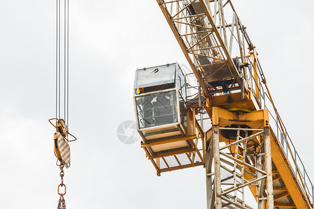 工业高塔起重机出租车和举吊装置 在建筑工地的灰天空背景上挂链钩 特写背景图片