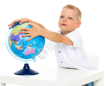 一个小男孩正在研究一个地球的地理学瞳孔工作室蓝色地理知识童年教育学生学校科学背景图片