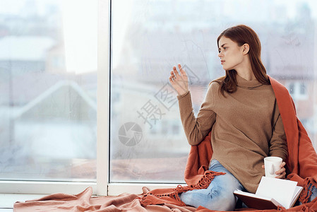 女人在窗台上喝着一杯酒 在清晨读一本书女士咖啡女性闲暇假期女孩杯子思维格子背景图片