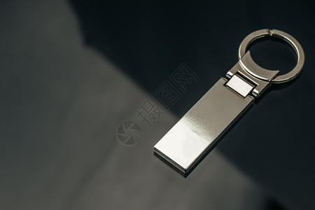 黑色玻璃背景上时尚的男性金属钥匙魅力钥匙圈空白饰品戒指吊坠品牌礼物标识推广广告背景图片