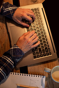 年轻人在咖啡馆里喝咖啡 使用笔记本电脑 男人的手在喝咖啡休息时间使用笔记本电脑博主屏幕潮人工具金融学习咖啡学生网络广告背景图片