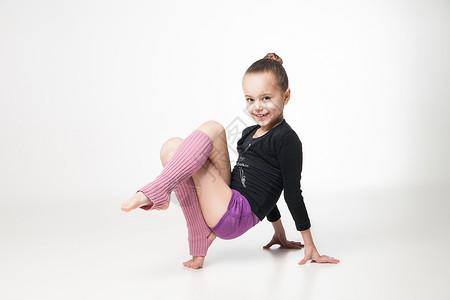白色年轻运动员漂亮的小女孩在白色背景上做体操的白人背景灵活性身体训练紫色行动力量杂技女性童年孩子背景