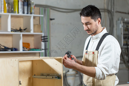 家具厂 小型公司和人的概念  青年工人在一家生产家具的工厂工作工艺职业木工木材商业技术制造业男人机器工具机械高清图片素材