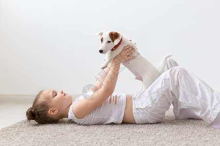 宠物和动物概念     童女玩小狗杰克罗素泰瑞犬类灰色白色黑发微笑乐趣睡衣幸福友谊地面背景图片