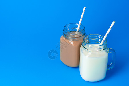 蓝底有新鲜牛奶的玻璃杯罐玻璃产品玻璃罐风味蓝色食物护理液体商品瓶子背景图片