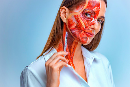 人体彩绘化妆品注射在脸上 有一半脸与皮肤下的肌肉结构的年轻女子 浅色背景下的医学培训模型保健女孩解剖学治疗青年身体美容药品皱纹彩绘背景