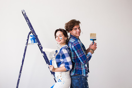 团队工作 修理和翻新概念     在新公寓中涂上油漆的男女梯子配件男人房子工具墙纸艺术乐器胶水女孩背景图片