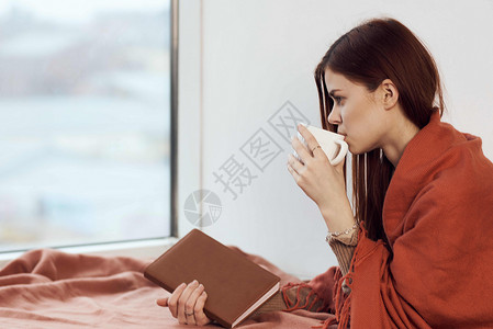 女人在窗台上喝着一杯酒 在清晨读一本书女孩思维咖啡闲暇杯子女性格子假期女士背景图片