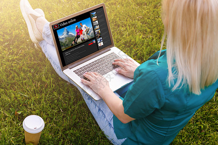 妇女通过笔记本电脑在线观看视频居住网络玩家互联网博主影响者手表网站旅行娱乐背景图片