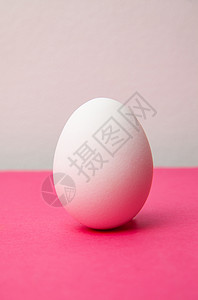 粉色表面白色新鲜鸡蛋背景图片