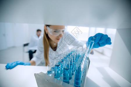 进行液体试验的科学家们对液态进行了测试样本学习蓝图物质管子化学女士男人蓝色研究背景图片