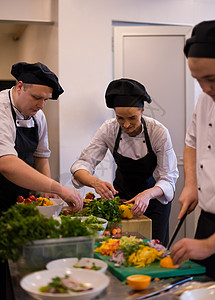 团队厨师和准备饭食的厨师烹饪酒店帽子女性男性同事盘子食物蔬菜男人背景图片