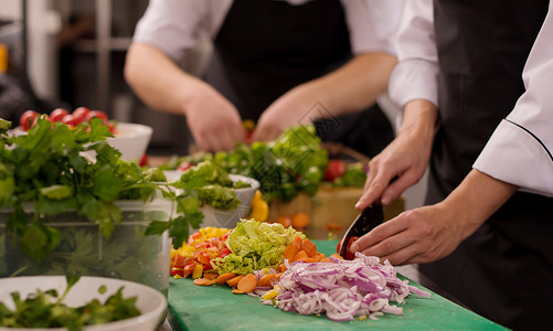 团队厨师和准备饭食的厨师餐厅帽子同事男人餐饮蔬菜服务职员商业食物背景图片