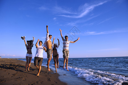 人群在海滩上奔跑生活闲暇友谊快乐假期娱乐海岸男性活力乐趣背景图片