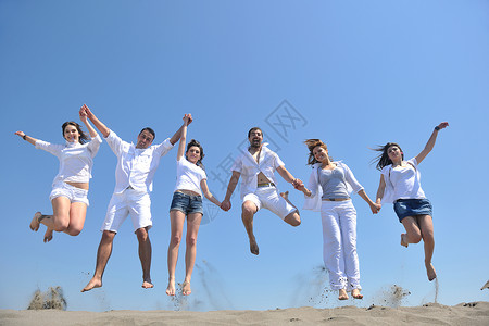 快乐的人群有乐趣 在海滩上奔跑喜悦男性旅行行动海洋团体闲暇朋友们娱乐海岸背景图片