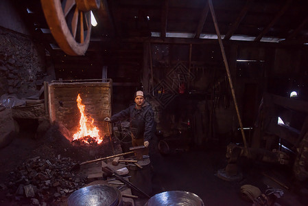 黑色火的素材年轻的传统铁匠与开着的火一起工作男人橙子金属市场把手火花建造火焰工匠艺术背景