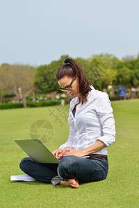 公园电脑公园里有笔记本电脑的妇女学生乐趣学习头发商业成人场地技术微笑工作背景