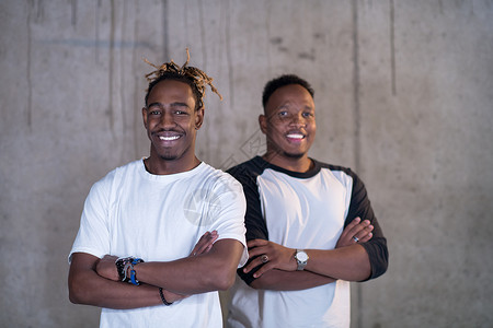 美国人微笑两名黑人商务人士在混凝土墙前的肖像人士企业家商务男人幸福团队工作成功办公室技术背景