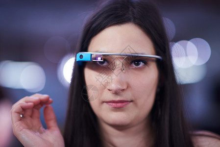 妇女使用虚拟现实工具计算机眼镜的虚拟真人电脑互联网科学护目镜展示数据电子女士眼睛屏幕控制背景图片