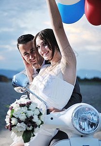 刚结婚的夫妇在海滩上骑白色摩托车气球喜悦夫妻微笑男人女士农村女性支撑女孩背景图片