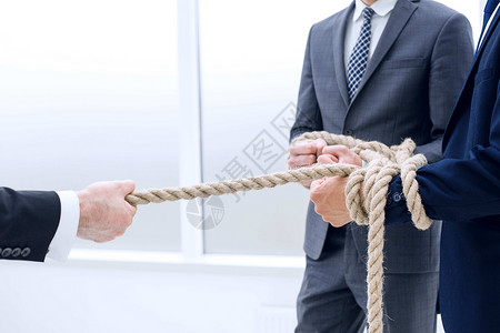 绳子手生意人用绳子拖着他的商业团队管理人员男性合伙成人工作工人合并挑战老板绳索背景