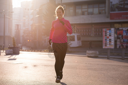 运动女运动员早上慢跑女士赛跑者城市活力跑步日出成人闲暇公园日落图片